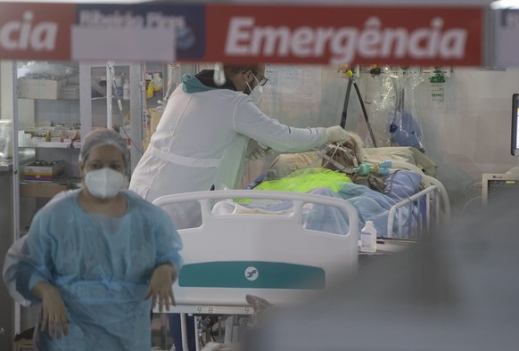 Health workers treat a COVID-19 patient at the emergency unit of a field hospital set up to treat COVID patients in Ribeirao Pires, greater Sao Paulo area, Brazil, Tuesday, April 13, 2021. (AP Photo/A ...