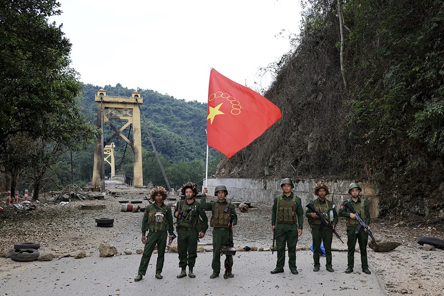 Members of the Myanmar National Democratic Alliance Army pose for a photograph with the group&#039;s flag in front of the Kunlong bridge in Kunlong township in Shan state, Myanmar, Sunday, Nov. 12, 20 ...