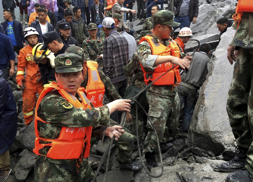 Emergency personnel work at the site of a massive landslide in Xinmo village in Maoxian County in southwestern China&#039;s Sichuan Province, Saturday, June 24, 2017. Dozens of people are feared burie ...