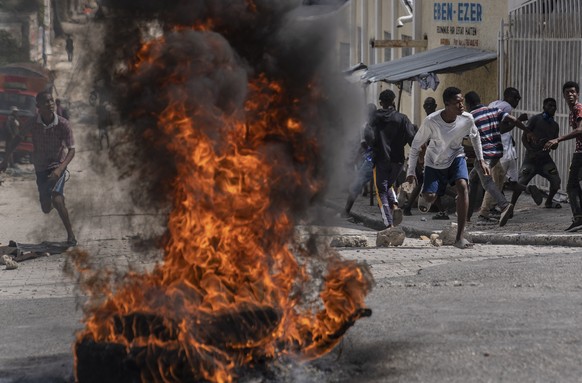 Protesters throw stones at police during a protest over the death of a journalist Romelson Vilsaint, in Port-au-Prince, Haiti, Sunday, Oct. 30, 2022. Vilsaint died Sunday after being shot in the head  ...