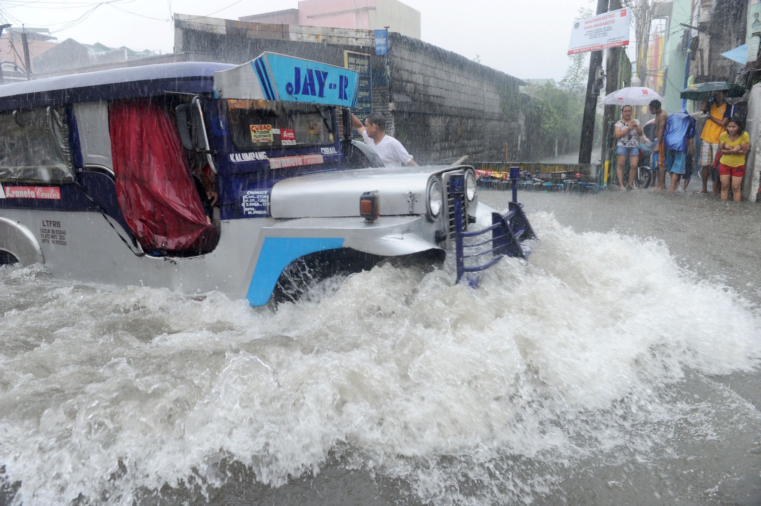 Ein sogenannter Jeepney bahnt sich den Weg durch die überfluteten Strassen der Hauptstadt.