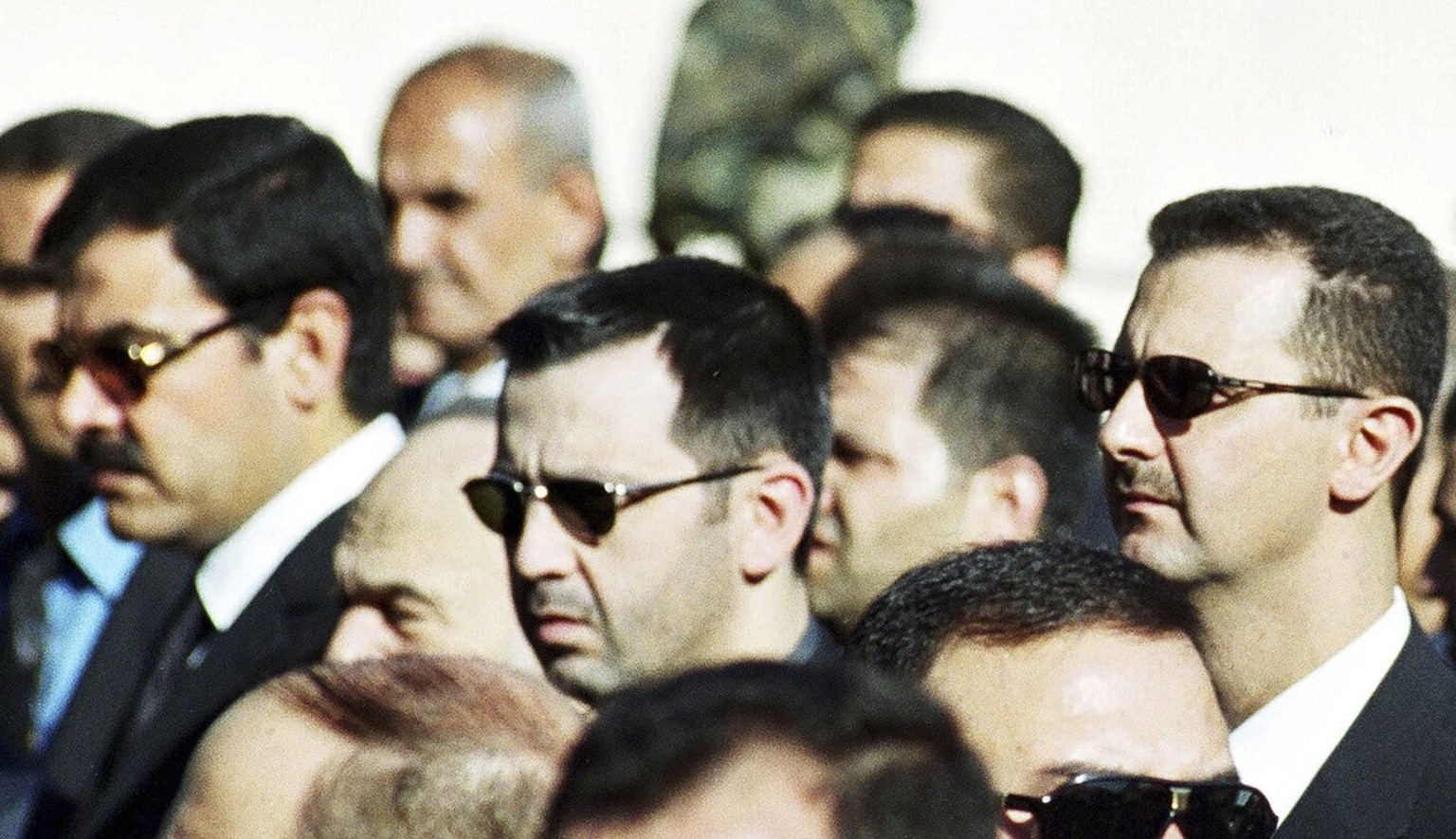 FILE - In this picture taken on June 13, 2000, Syrian President Bashar al-Assad, right, his brother Maher, centre, and brother-in-law Major General Assef Shawkat, left, stand during the funeral of lat ...
