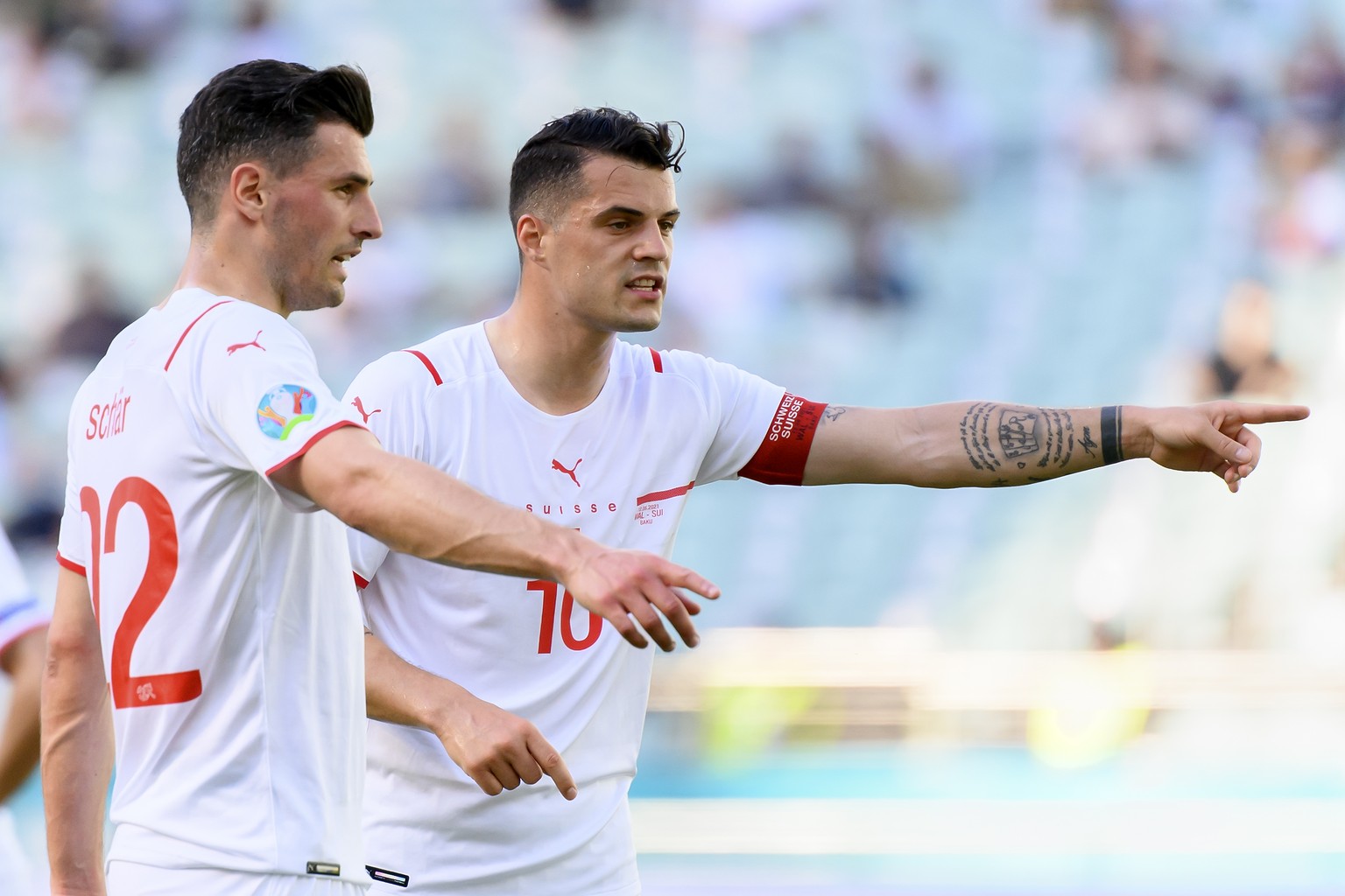 Switzerland's defender Fabian Schaer, left, and Switzerland's midfielder Granit Xhaka, right, react during during the Euro 2020 soccer tournament group A match between Wales and Switzerland at the Oly ...