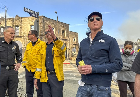 California Governor Gavin Newsom, right, surveys damage in Pacific Palisades with CalFire&#039;s Nick Schuler during the Palisades Fire on Wednesday, Jan. 8, 2025, in Pacific Palisades, Cali. (Jeff Gr ...