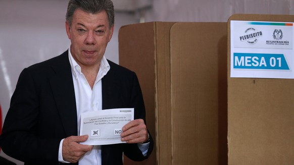 Colombia&#039;s President Juan Manuel Santos shows his vote for a referendum on a peace deal between the government and Revolutionary Armed Forces of Colombia (FARC) rebels at Bolivar Square in Bogota ...