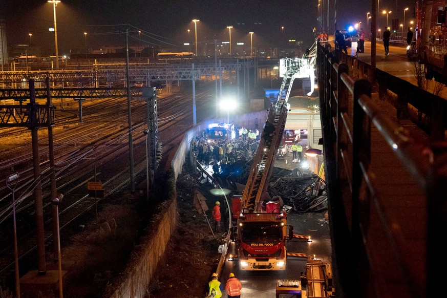 epa10898540 Rescue personnel work at the site where a passenger bus with people on board fell from an elevated section ending up on the railway track that runs alongside the road in Mestre, near Venic ...