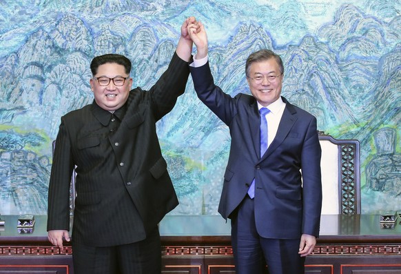 FILE - In this April, 27, 2018, file photo, North Korean leader Kim Jong Un, left, and South Korean President Moon Jae-in raise their hands after signing a joint statement at the border village of Pan ...