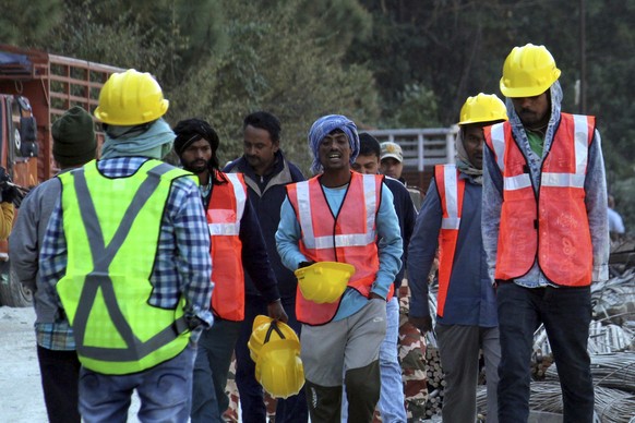 Rescuers walk near the site of an under-construction road tunnel that collapsed in mountainous Uttarakhand state, India, Friday, Nov. 17, 2023. Rescuers drilled deeper into the rubble of a collapsed r ...