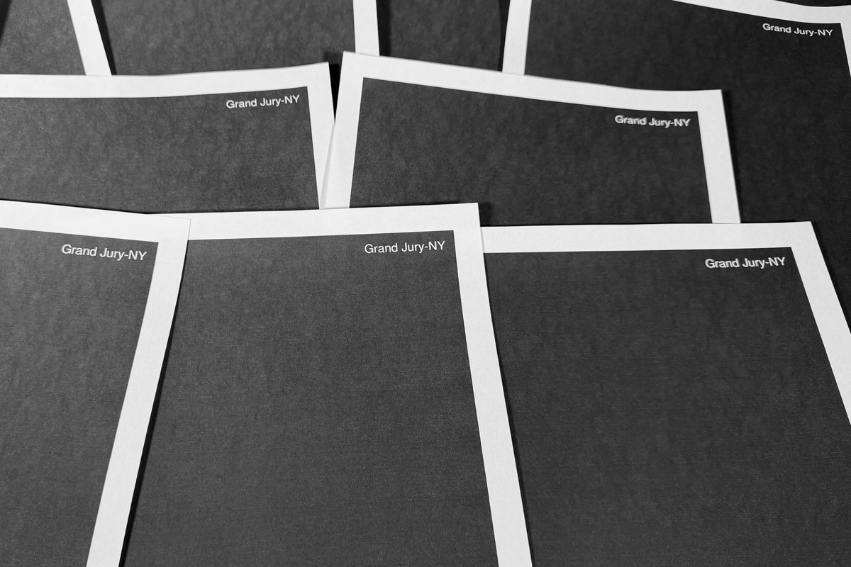 Pages from a totally redacted New York grand jury file into Jeffrey Epstein and Ghislaine Maxwell, released by the U.S. Justice Department, is photographed Friday, Dec. 19, 2025, in Washington. (AP Ph ...