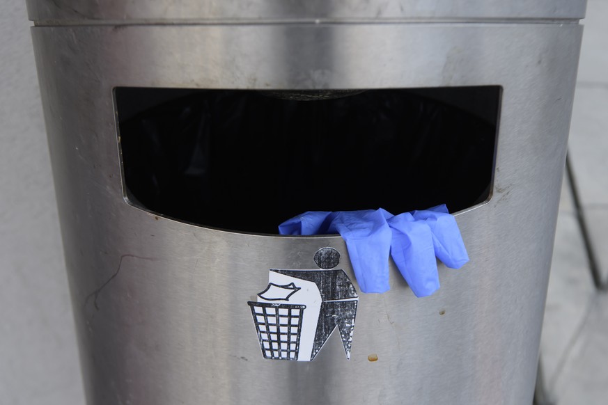 Un gant en latex jete dans une poubelle est photographie devant l?Hoptial cantonale de Fribourg (HFR), ce mercredi 25 mars 2020, a Fribourg. (KEYSTONE/Anthony Anex)