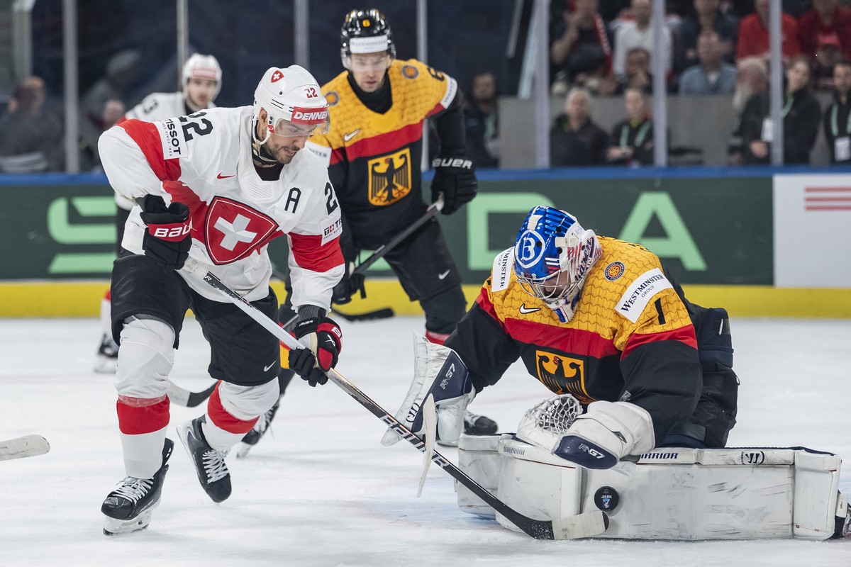 Germany's goaltender Jonas Stettmer, right, stops the puck of Switzerland's Nino Niederreiter, left, during the 2026 IIHF Men's Ice Hockey World Championship preliminary round group A g ...