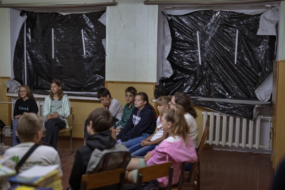 Students sit in a blast-damaged classroom to receive textbooks ahead of this week&#039;s beginning of the academic year at Mykhailo-Kotsyubynske&#039;s lyceum, which was bombed by Russian forces on th ...