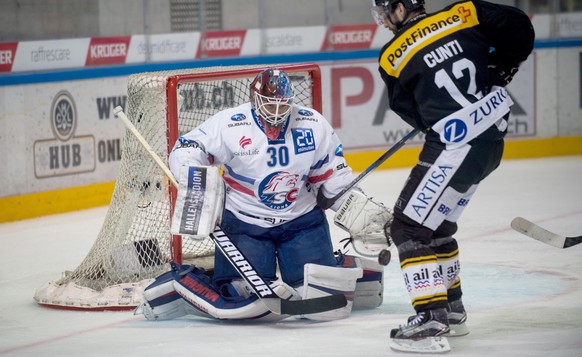 Zurich&#039;s goalkeeper Lukas Flueeler and Lugano&#039;s player Luca Cunti, during the third match of the playoff final of the National League of the ice hockey Swiss Championship between the HC Luga ...