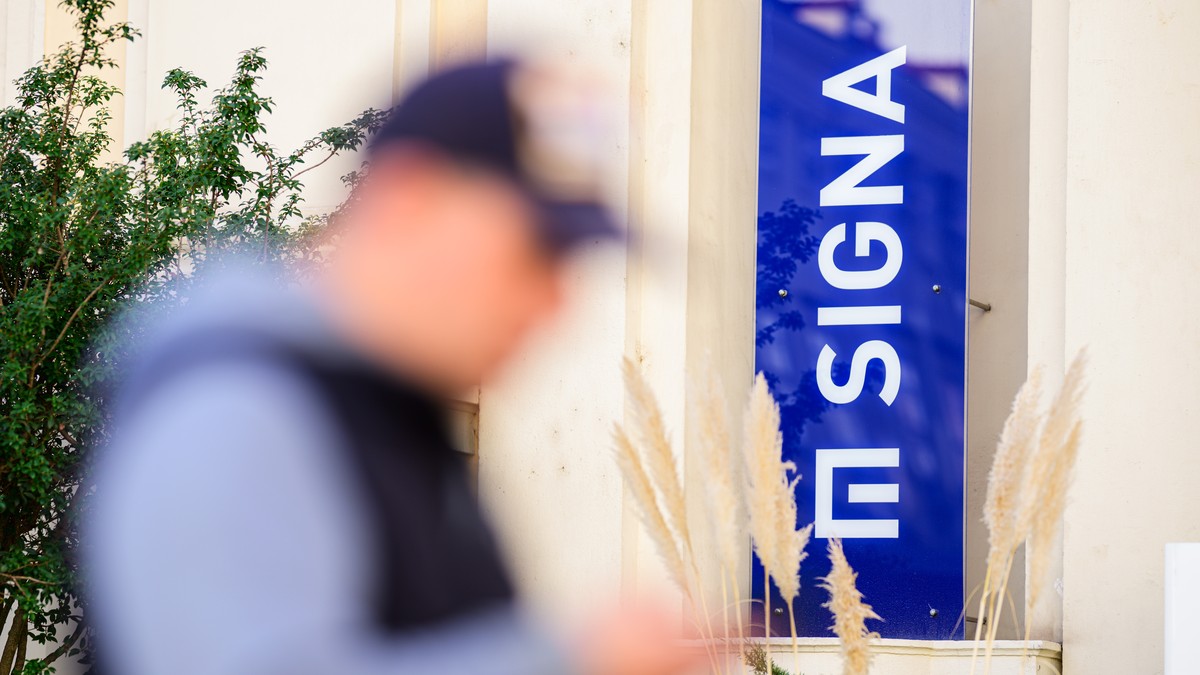 epa10964336 A man passes by a logo of Austrian real estate and trading company Signa Holding at the group's Vienna office, in Vienna, Austria, 08 November 2023. Rene Benko, Austrian business man  ...