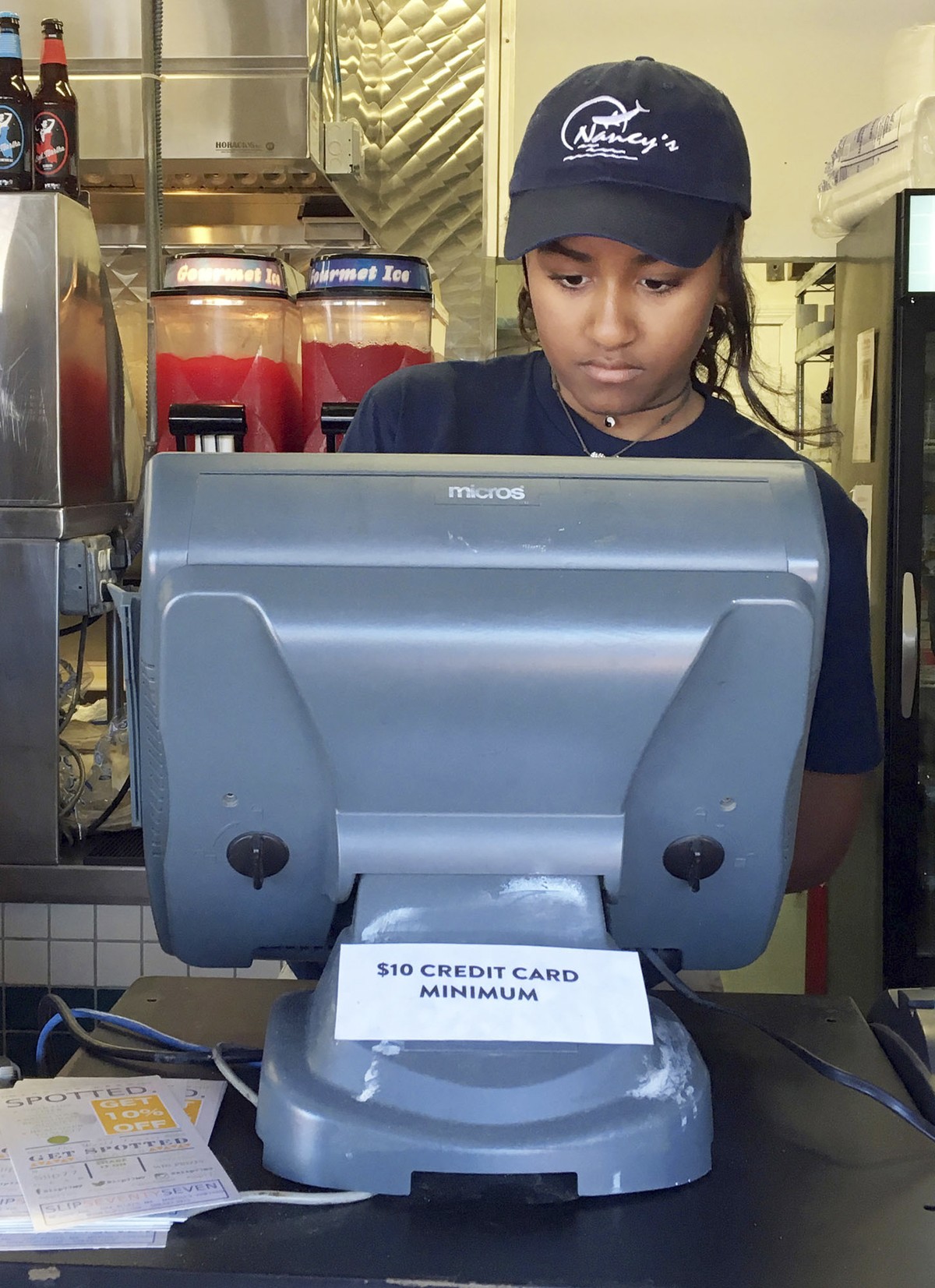 In this Wednesday, Aug. 3, 2016 photo Sasha Obama, daughter of President Barack Obama, works the register at Nancy's Restaurant in Oak Bluffs, Mass., on the island of Martha's Vineyard. (Bos ...