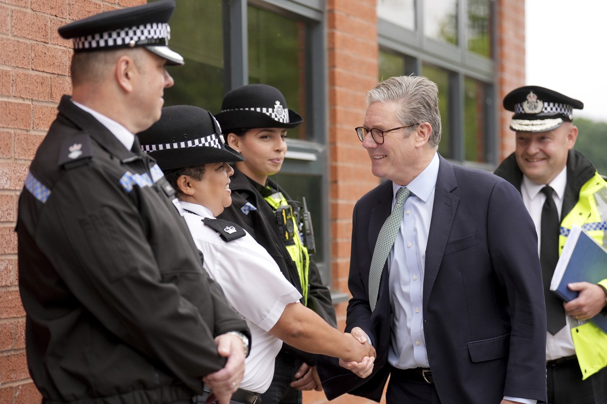 British Prime Minister Sir Keir Starmer, second right, greets members of the West Midlands Police Force as he arrives at Arden Academy in Solihull, West Midlands, England, Thursday Aug. 8, 2024. (Joe  ...