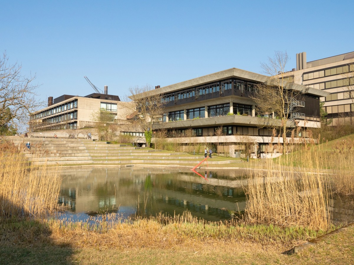 Zurich University, Switzerland, has a campus at the edge of the city. Concrete buildings within the Irchelpark, a popular garden with fields and lakes.