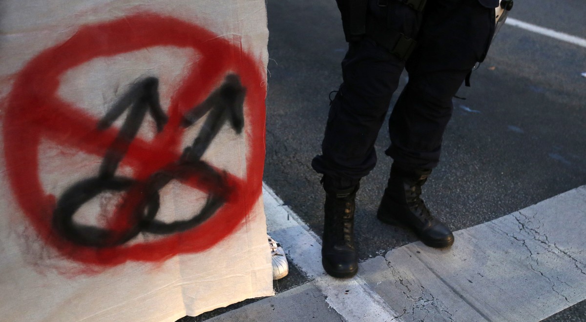 A Serbian police officer stands by a protester that holds an anti-gay banner, during an anti-gay march organized in Belgrade, Serbia, Saturday, Sept. 19, 2015. The Belgrade gay pride march will take p ...