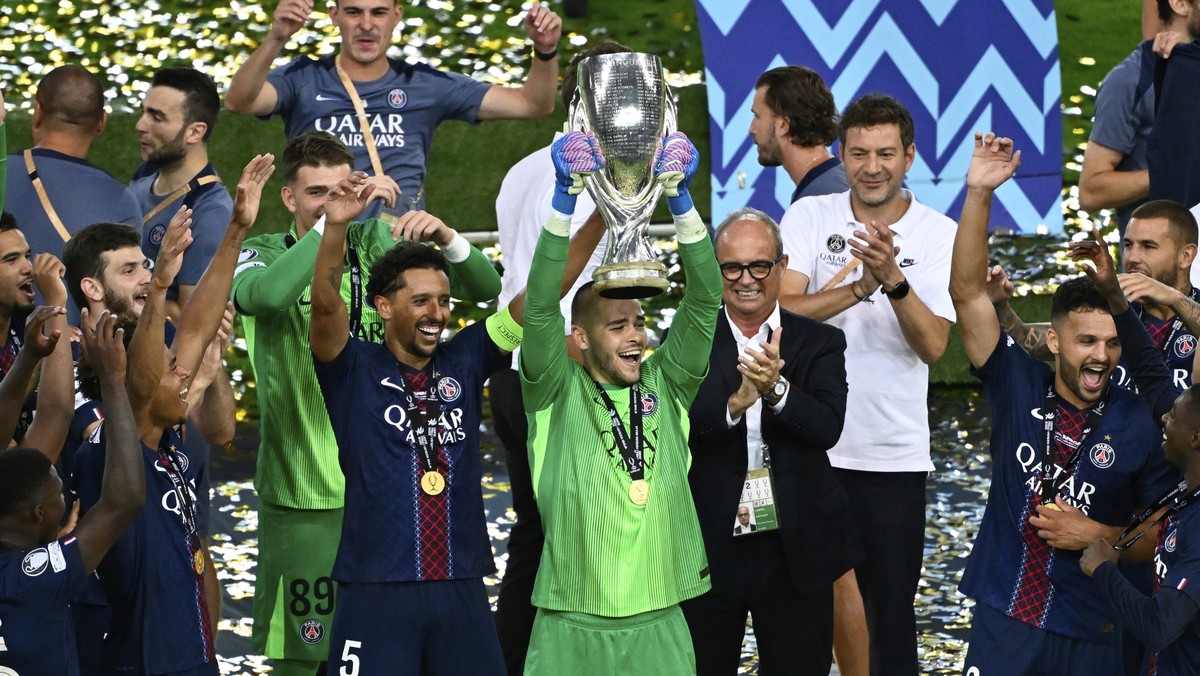 PSG's goalkeeper Lucas Chevalier lifts the trophy as he celebrates with teammates after the UEFA Super Cup soccer match between Paris Saint-Germain and Tottenham Hotspur in Udine, Italy, Thursday ...