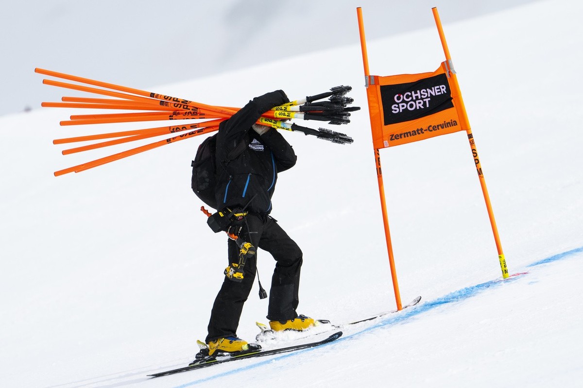 Workers remove gates after the women's downhill race was cancelled due to strong winds, on the new ski course "Gran Becca" at the Alpine Skiing FIS Ski World Cup Zermatt-Cervinia, in Ce ...