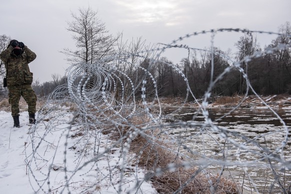 epa09654985 Polish border guards patrol at the Polish-Belarusian border near Koden village and the Bug River, Poland, 23 December 2021. Poland, Lithuania and Latvia have been tackling increased migrat ...