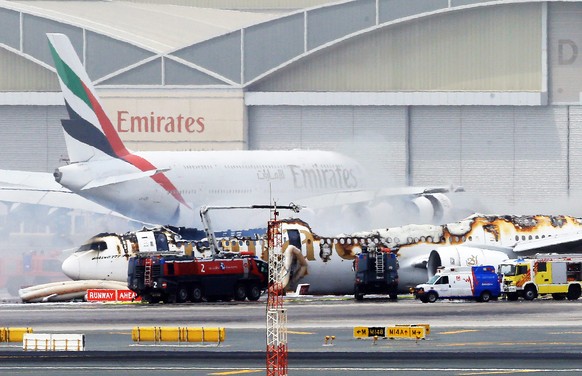 epa05452911 An Emirates airlines Boeing 777-300 A6-EMW plane flight number EK521 from Trivandrum to Dubai lays on the ground in Dubai airport after being gutted by fire due to a mechanical failure at  ...