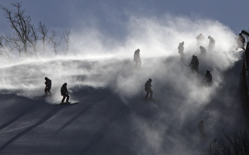 Course crew are shrouded in snow as they carry ski gates after the women&#039;s giant slalom was postponed due to high winds at the 2018 Winter Olympics at the Yongpyong Alpine Center, Pyeongchang, So ...