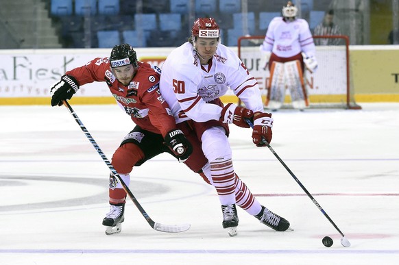 Mathias Hansen Bau, right, of Denmark fights for the puck with Alexander Rauchenwald of Austria during their ice hockey friendly bronze match in Tuskecsarnok Sports Hall in Budapest, Hungary, Sunday,  ...