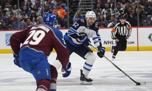 Winnipeg Jets right wing Nino Niederreiter, back, looks to pass the puck as Colorado Avalanche center Nathan MacKinnon defends during the second period of Game 3 of an NHL hockey Stanley Cup first-rou ...