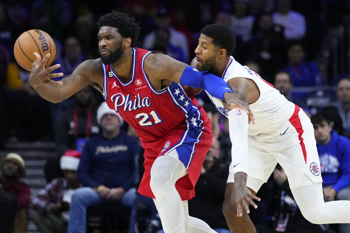 FILE - Philadelphia 76ers' Joel Embiid, left, tries to hang onto the ball against Los Angeles Clippers' Paul George during the first half of an NBA basketball game, Friday, Dec. 23, 2022, in ...