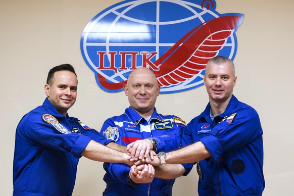In this handout photo released by Roscosmos Space Agency, Russian cosmonauts, commander Oleg Аrtemiev, centre, flight engineers Denis