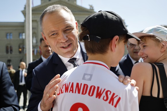 epa12998158 President of the Republic of Poland Karol Nawrocki (C) talks to a boy wearing a Lewandowski football shirt during a state visit in Bern, Switzerland, 27 May 2026. The Polish president is o ...