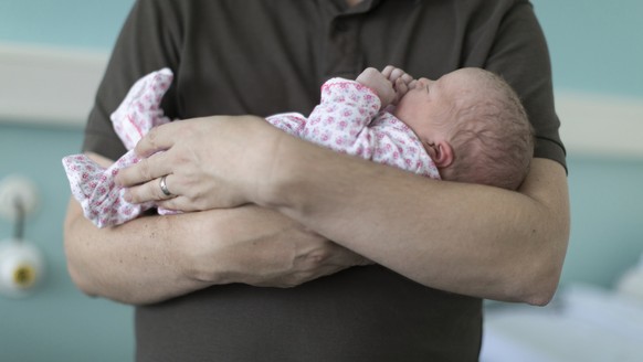 ZUM THEMA VATERSCHAFTSURLAUB STELLEN WIR IHNEN HEUTE, MITTWOCH, 25. OKTOBER 2017, FOLGENDES BILDMATERIAL ZUR VERFUEGUNG --- A father holds his newborn infant named Julia at the maternity unit of the T ...