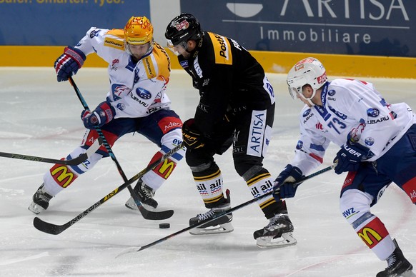 Luganoâs player Philippe Furrer, center, fights for the puck with Zurich&#039;s player Robert Nilsson, left, during the preliminary round game of National League Swiss Championship 2017/18 between H ...