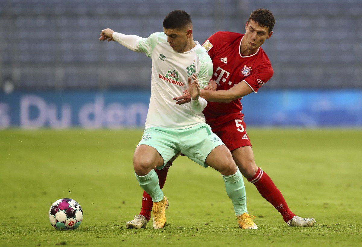 Bremen's Milot Rashica, left, duels for the ball with Bayern's Benjamin Pavard during the German Bundesliga soccer match between FC Bayern Munich and SV Werder Bremen in Munich, Germany, Sat ...