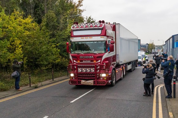 epa07943551 Police drive the lorry container along the road from the scene in Waterglade Industrial Park in Grays, Essex, Britain, 23 October 2019. A total of 39 bodies were discovered inside a lorry  ...