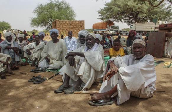 In this photo provided by UNICEF, a group of refugees rests under the shade of a tree to protect themselves from the sun and heat after crossing into the village of Koufroun, near the Chad-Sudan borde ...
