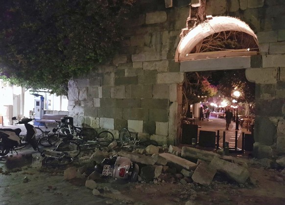 People walk near a damaged building after an strong earthquake on the Greek island of Kos early Friday, July 21, 2017. A powerful earthquake struck Greek islands and Turkey&#039;s Aegean coast early F ...