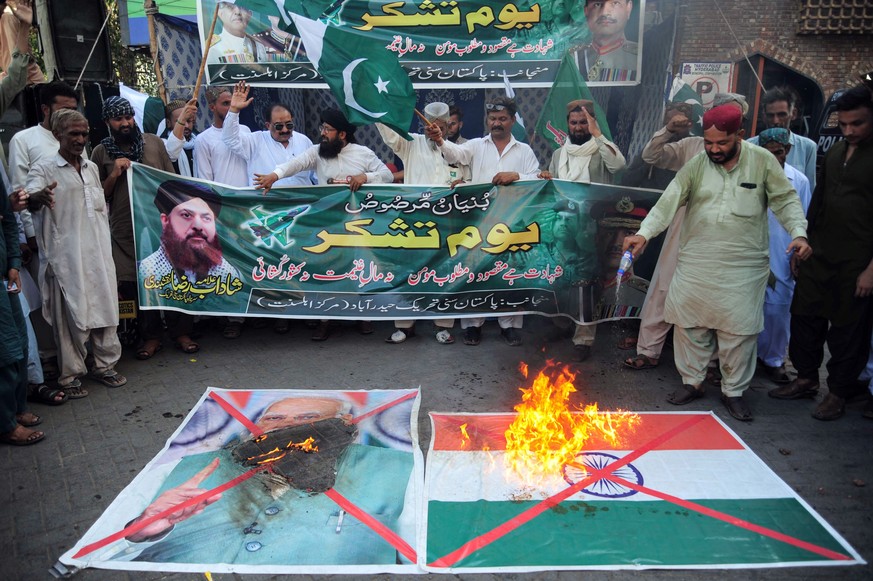 epa12106282 Supporters of the Islamic political party Sunni Tehreek burn a mock Indian flag and an image of Indian Prime Minister Narendra Modi during a protest rally to mark Youm-e-Tashakur (Thanksgi ...