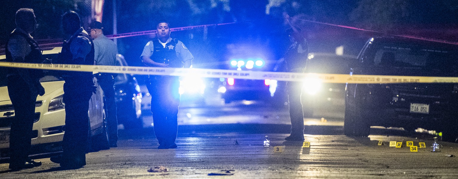 In this Aug. 5, 2018 photo, police investigate the scene where multiple people were shot in Chicago. Police Superintendent Eddie Johnson plans to discuss the weekend violence during a Monday news conf ...