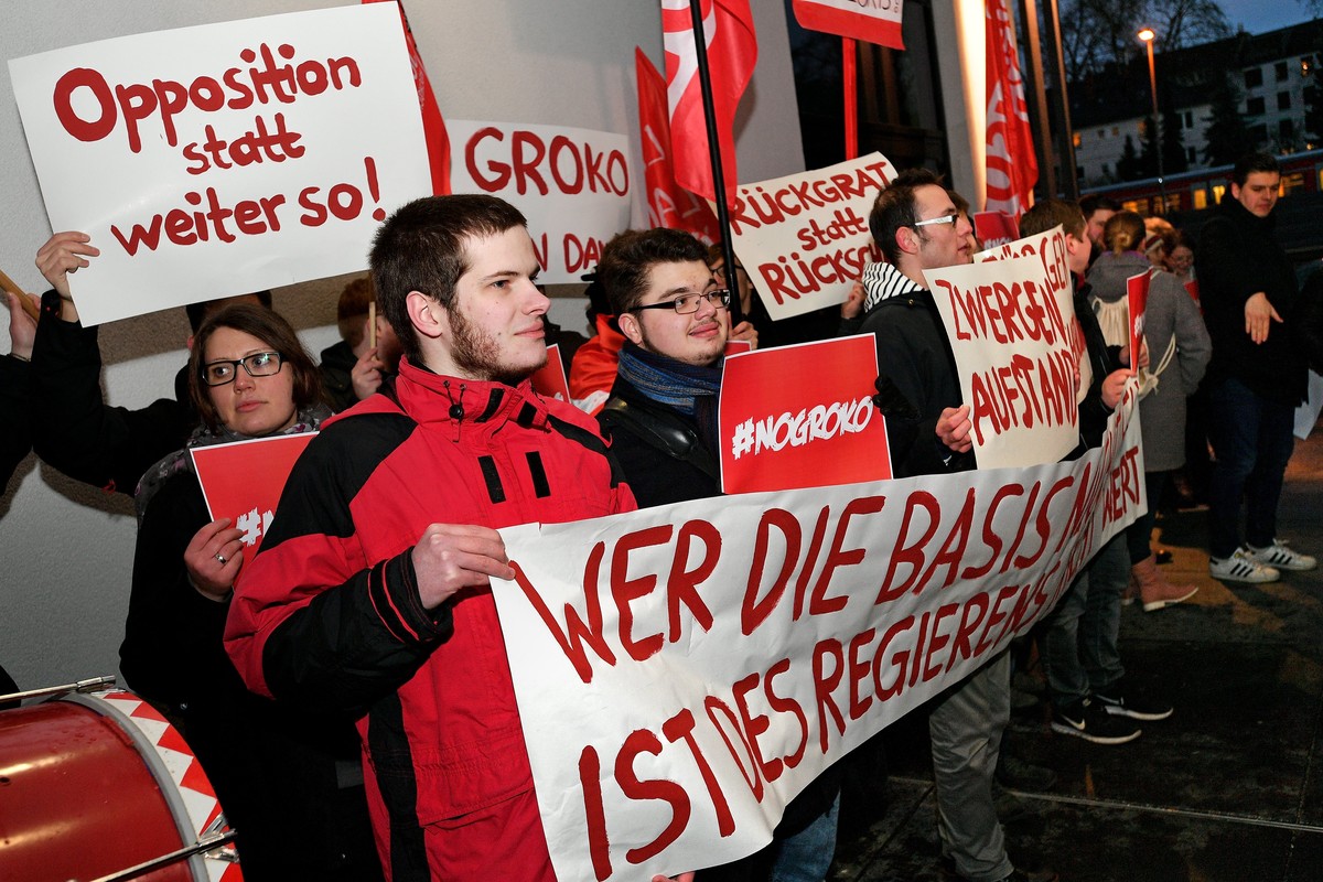 epa06444205 'Young Social' party members show a banner reading 'Who does not honor the base is not worthy of governing!' before the leader of the Social Democratic Party (SPD) Mart ...