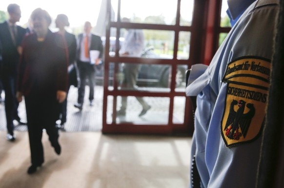 A security officer of Germany&#039;s Bundesamt fuer Verfassungsschutz (BfV), the domestic intelligence service of the Federal Republic of Germany, stands guard as German Chancellor Angela Merkel arriv ...