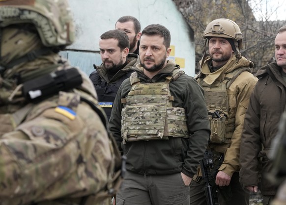Ukrainian President Volodymyr Zelenskyy examines the site of a recent battle in Bucha close to Kyiv, Ukraine, Monday, Apr. 4, 2022. Russia is facing a fresh wave of condemnation after evidence emerged ...