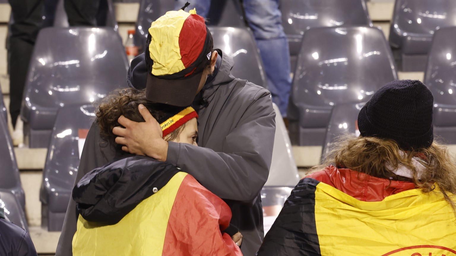 A supporter is comforted on the stands after suspension of the Euro 2024 group F qualifying soccer match between Belgium and Sweden at the King Baudouin Stadium in Brussels, Monday, Oct. 16, 2023. The ...
