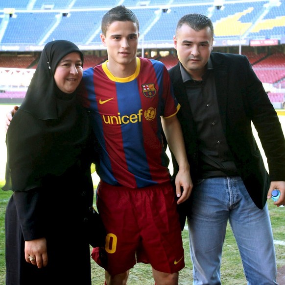 epa02506117 Dutch new midfielder of F.C. Barcelona Ibrahim Afellay (C) poses for the photographers with his mother Habiba (L) and his brother Ali during his official presentation to the media at Camp  ...