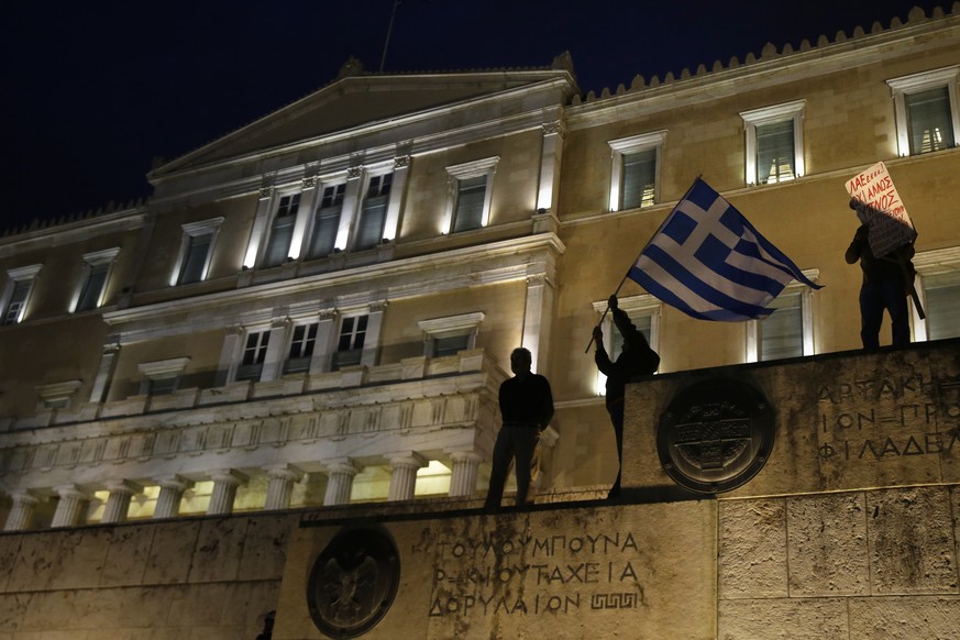 A man waves a Greek flag in front of the Greek Parliament during a rally against new austerity measures in Athens, Thursday, May 18, 2017. Protesters took to the streets of central Athens for the seco ...