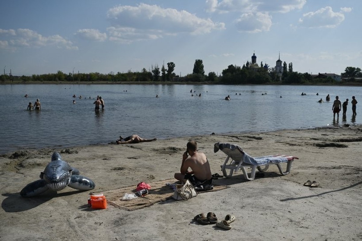 Des gens se détendent au bord d'un lac.