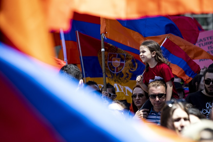 epa07526190 A child sits on her father&#039;s shoulders in the middle of the crowd as thousands take part in a demonstration to commemorate the 104th Anniversary of the Armenian genocide in front of t ...