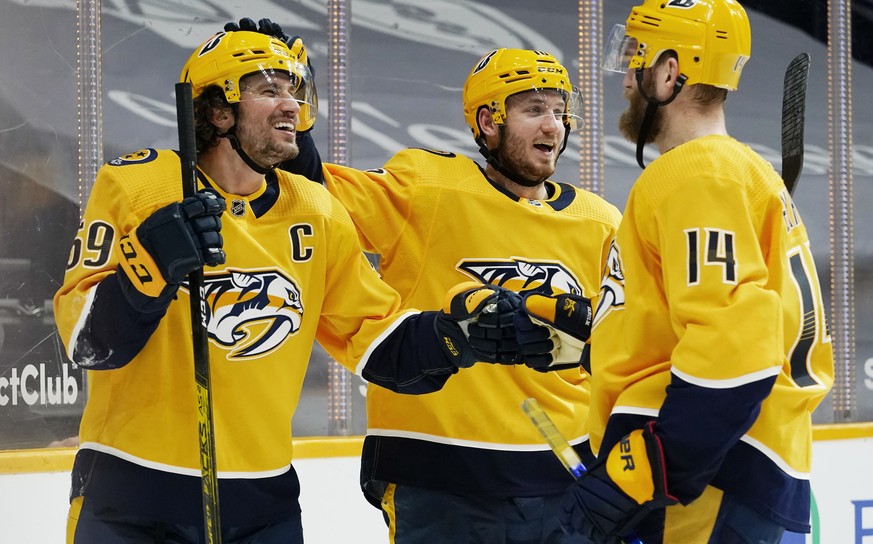 Nashville Predators defenseman Roman Josi (59) celebrates with Colton Sissons (10) and Mattias Ekholm (14) after Josi scored the winning goal against the Chicago Blackhawks in overtime of an NHL hocke ...