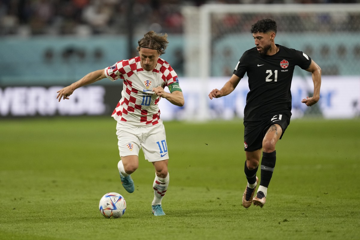 Croatia's Luka Modric, left, controls the ball past Canada's Jonathan Osorio during the World Cup group F soccer match between Croatia and Canada, at the Khalifa International Stadium in Doh ...